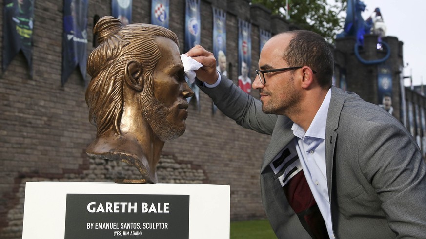 Artist Emanuel Santos, wipes a bust of Real Madrid and Wales soccer player Gareth Bale that he created, after it was placed on display in Cardiff, Wales Wednesday May 31, 2017, ahead of this weekend&# ...