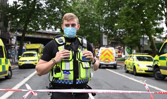 epa09308316 Police and rescue services at the scene of a fire at Elephant and Castle in central London, Britain, 28 June 2021. A huge fire broke out at a garage under railway tracks at Elephant and Ca ...