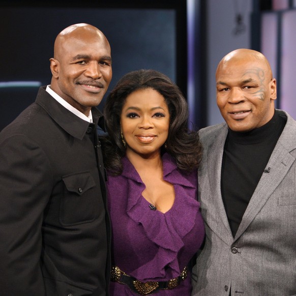 In this photo provided by Harpo, Inc., talk-show host Oprah Winfrey poses with former world champion boxers Mike Tyson, right, and Evander Holyfield on a live episode of &quot;The Oprah Winfrey Show,& ...