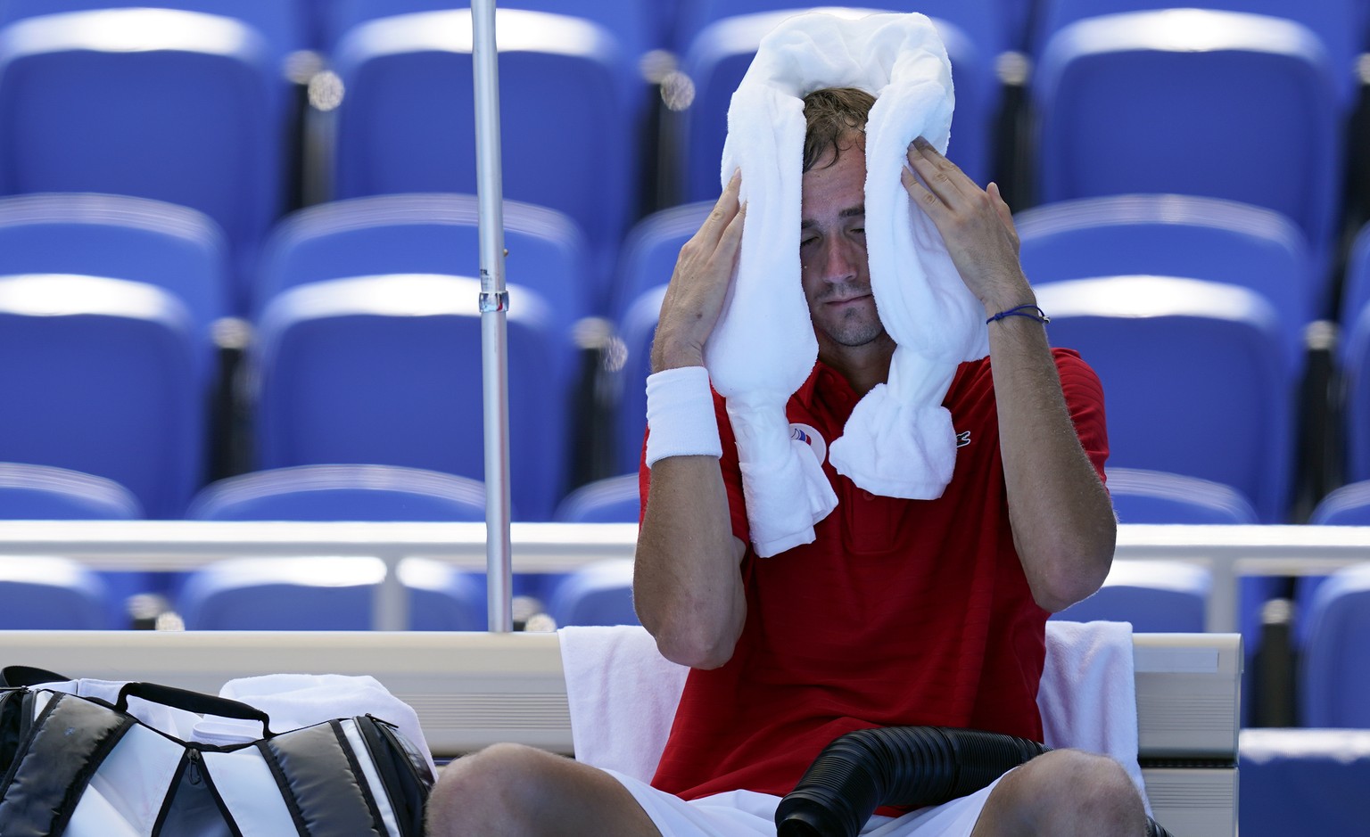 Daniil Medvedev, of the Russian Olympic Committee, cools off during a changeover in a tennis match against Alexander Bublik, of Kazakhstan, during at the 2020 Summer Olympics, Saturday, July 24, 2021, ...