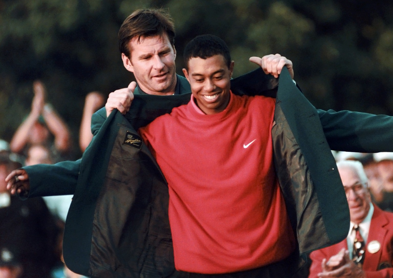 FILE - In this April 13, 1997, file photo, Masters champion Tiger Woods receives his green jacket from the previous year&#039;s winner Nick Faldo, rear, at the Augusta National Golf Club in Augusta, G ...