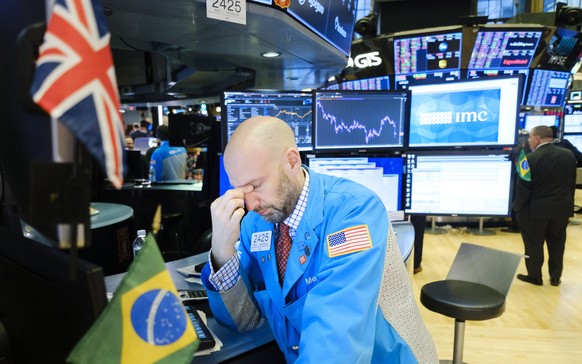 epaselect epa08245142 A trader rubs his eyes at the end of the day on the floor of the New York Stock Exchange in New York, New York, USA, 24 February 2020. Stocks around the world are broadly lower a ...