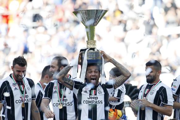 Juventus&#039; Dani Alves lifts the trophy as Juventus players celebrate winning an unprecedented sixth consecutive Italian title, at the end of the Serie A soccer match between Juventus and Crotone a ...