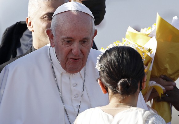 Children give Pope Francis, center, flowers as he arrives at Irbil International Airport, Iraq, Sunday, March 7, 2021. Francis is urging Iraq