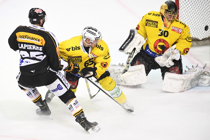 Lugano&#039;s player Maxim Lapierre, Bern&#039;s player Ramon Untersander and Bern&#039;s goalkeeper Leonardo Genoni, from left, during the second Playoff semifinal game of National League A (NLA) Swi ...