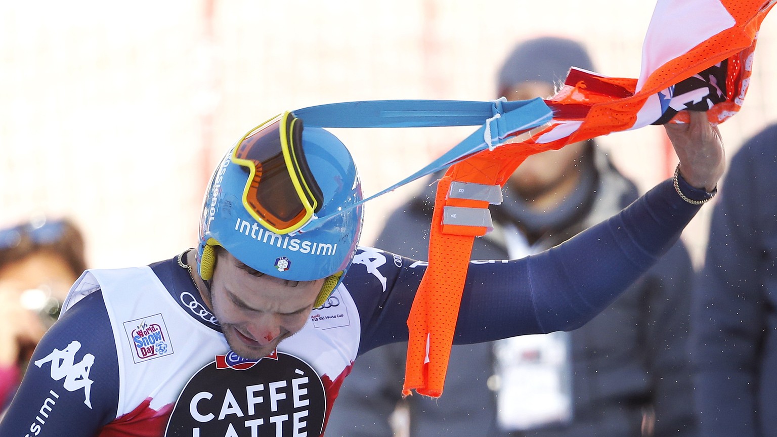 Christof Innerhofer of Italy removes part of a gate that remained entrapped in his race glasses after crossing the finish line of the men&#039;s downhill race at the Alpine Skiing World Cup in Santa C ...