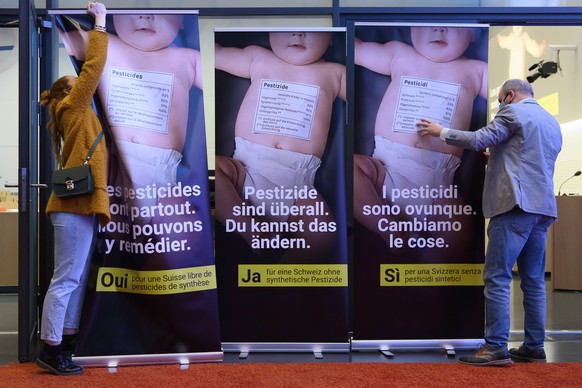 Zwei Personen installieren die Plakaten vor einer Medienkonferenz des Initiativkommitees &quot;Fuer eine Schweiz ohne synthetische Pestizide&quot;, am Dienstag, 30. Maerz 2021 in Bern. (KEYSTONE/Antho ...