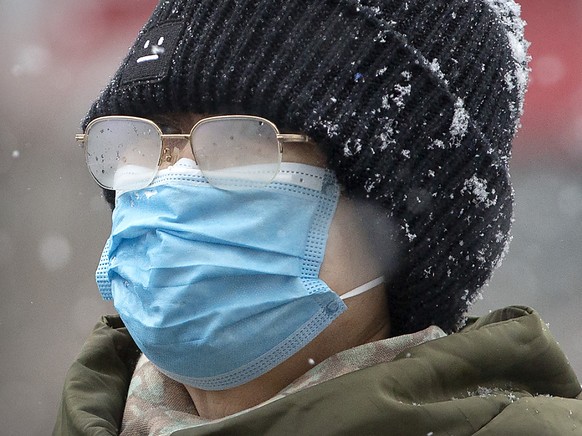 Bei Schneefall ist der Mundschutz eher hinderlich. Und doch schützen sich die Chinesen damit vor der Ansteckung durch das Coronavirus. (Archivbild)