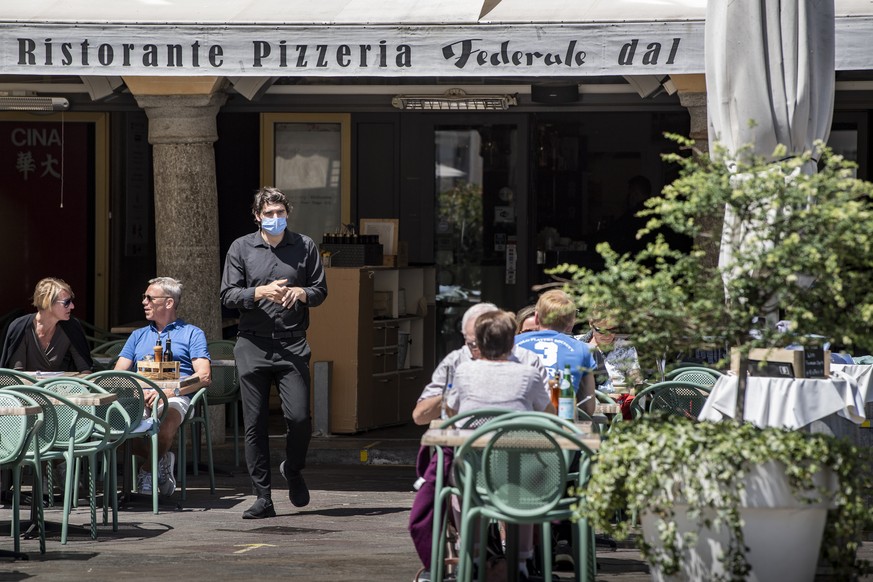 Ein Kellner steht vor dem geoeffneten Innenbereich eines Restaurants in Lugano, am Montag 31. Mai 2021. Ab heute duerfen die Restaurants auch die Tische im Innern wieder besetzen. (KEYSTONE/Ti-Press/P ...