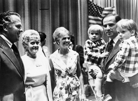 FILE - In this summer 1972 file photo, Joe Biden, carries both of his sons, Joseph, left, and Robert during an appearance at the Democratic state convention At center is his wife Neilia Biden, who was ...