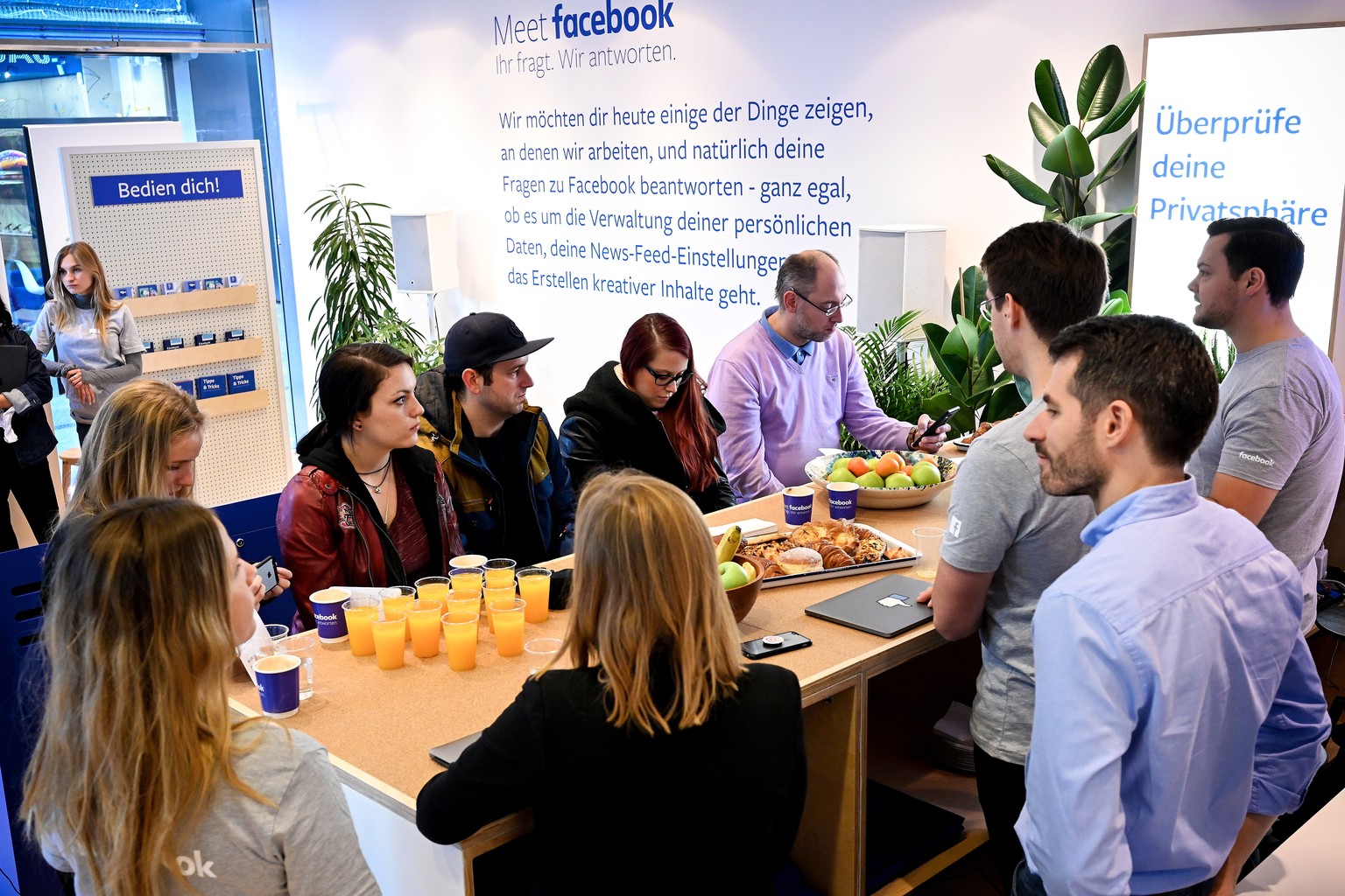 epa07170186 Facebook employees (R) talk with visitors at the Facebook pop-up store in Cologne, Germany, 16 November 2018. The shop is open for customers from 16 to 17 November 2018. Visitors will have ...