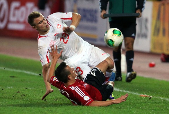FILE - In this Friday Oct. 11, 2013, file photo, Albanias Ergys Kace, bottom, fights for the ball with Switzerland&#039;s Xherdan Shaqiri, during their World Cup Group E qualifier soccer match in Tir ...