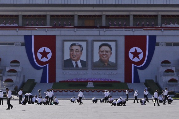 North Koreans prepare under portraits of the country&#039;s late leaders, Kim Il Sung, left, and Kim Jong Il, right, on Kim Il Sung Square, ahead of the 70th anniversary of North Korea&#039;s founding ...