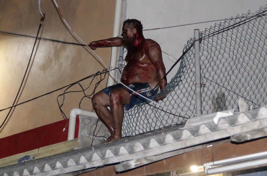 epa05975596 Russian citizen, Aleksey Makeev (name unconfirmed), sits on a fence atop a building while covered in blood after an angry mob tried to lynch him for reportedly insulting Mexican people on  ...
