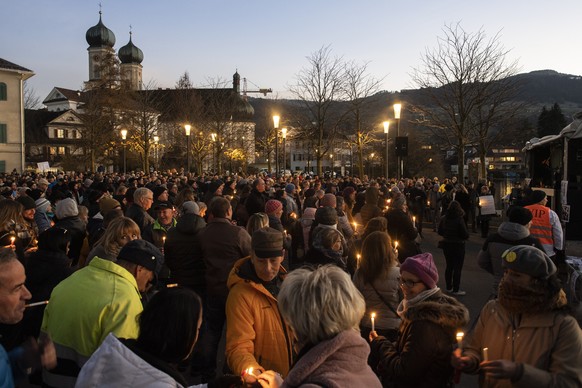 Menschen zuenden Kerzen an einer Kundgebung gegen die Corona Massnahmen von Bund und Kanton an, am Samstag, 21. November 2020 in Lachen. (KEYSTONE/Ennio Leanza).