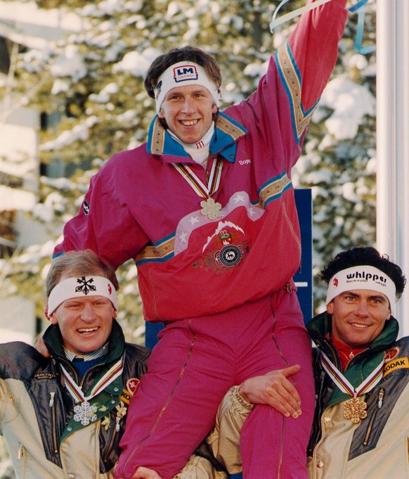 DOWNHILL MEDALIST: Downhill Gold medalist Hansjoerg Tauscher, of West Germany, rides the shoulders Switzerlands second place finisher Peter Mueller (left) and Karl Alpinger at the World Alpine Champio ...
