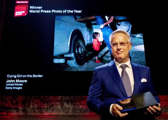 epaselect epa07500111 Winner of the World Press Photo 2019 Picture of the Year Award photographer John Moore poses in front of his winning picture Crying Girl on the Border during the World Press Phot ...