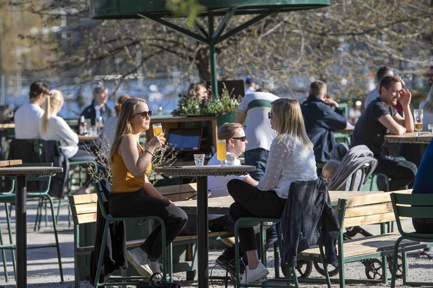 epa08378414 People gather in a cafe to enjoy the warm spring weather in Stockholm, Sweden, 22 April 2020, amid the ongoing coronavirus COVID-19 pandemic. Countries around the world are taking increase ...