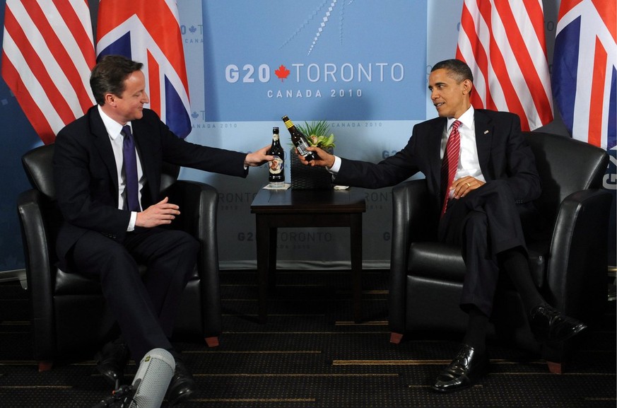 epa02224670 US President Barack Obama (R) and Prime Minister of the United Kingdom David Cameron (L) clink bottles of beer during their bilateral meeting at the G20 summit in Toronto, Canada, 26 June  ...