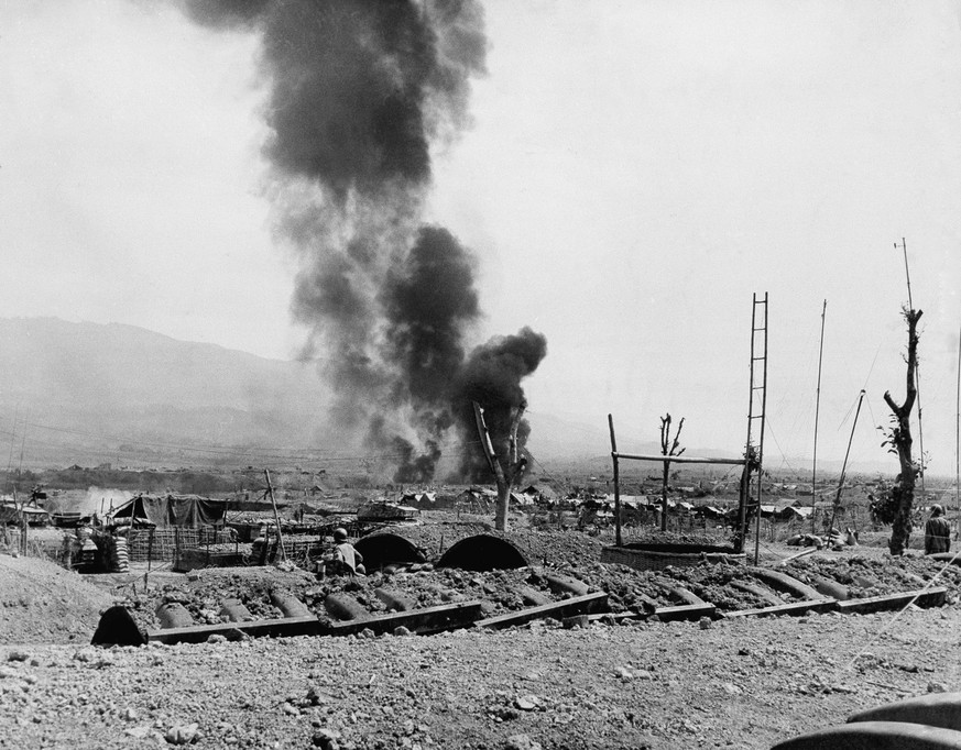 Napalm bombs burst over trenches occupied by Communist-led Vietminh besiegers of Dien Bien Phu, March 28, 1954. French Union defenders of the fortress occupy covered trench positions in the foreground ...