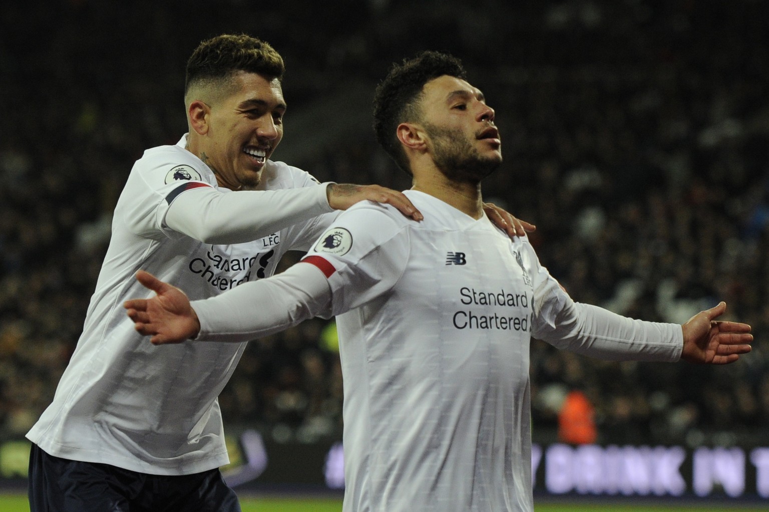epa08176963 Alex Oxlade-Chamberlain (R) of Liverpool celebrates with teammate Roberto Firmino after scoring during the English Premier League soccer match between West Ham United and Liverpool FC held ...