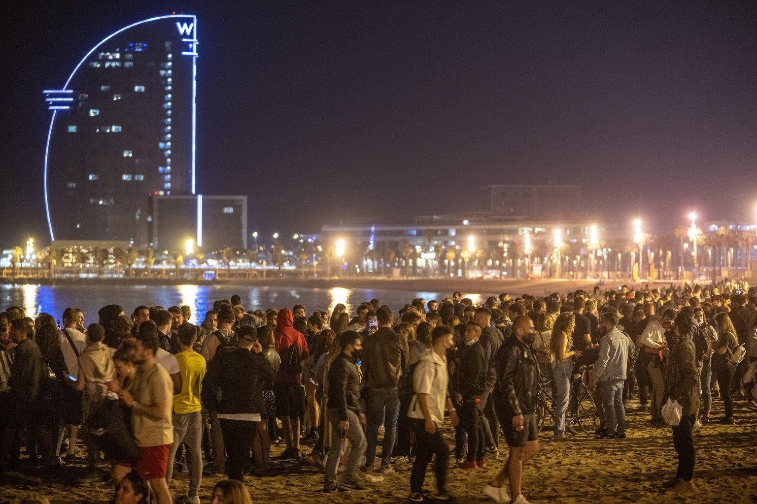 People crowded on the beach in Barcelona, Spain, Sunday, May 9, 2021. Barcelona residents were euphoric as the clock stroke midnight, ending a six-month-long national state of emergency and consequent ...