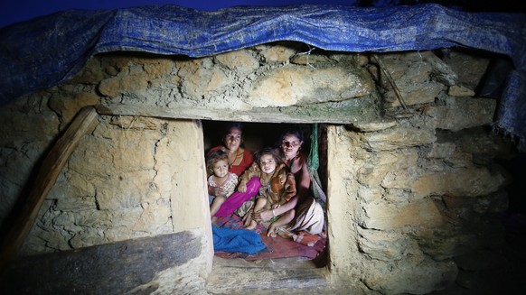epa07308059 (FILE) - Pabitra Devi Jaisi (R), aged 29, and Sarada Jaisi (L), aged 30, share a tiny community &#039;Chapuadi&#039; hut with their children at Mastamandali village in Acham disctrict, Nep ...