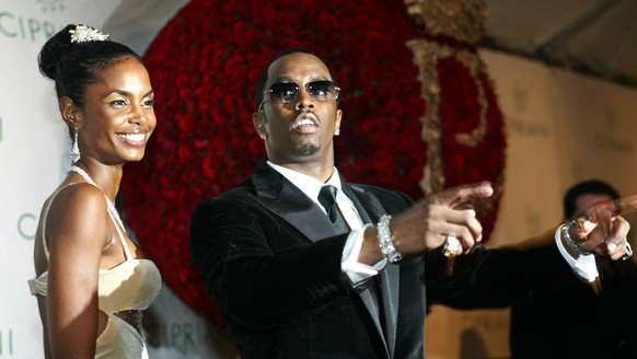 File-This Nov. 4, 2004, file photo shows Sean &quot;P. Diddy&quot; Combs directing photographers as they sing &quot;Happy Birthday,&quot; to him as his date Kim Porter, left, listens, after Combs arri ...