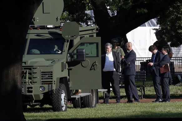 Attorney General William Barr, center, stands in Lafayette Park across from the White House as demonstrators gather to protest the death of George Floyd, Monday, June 1, 2020, in Washington. Floyd die ...