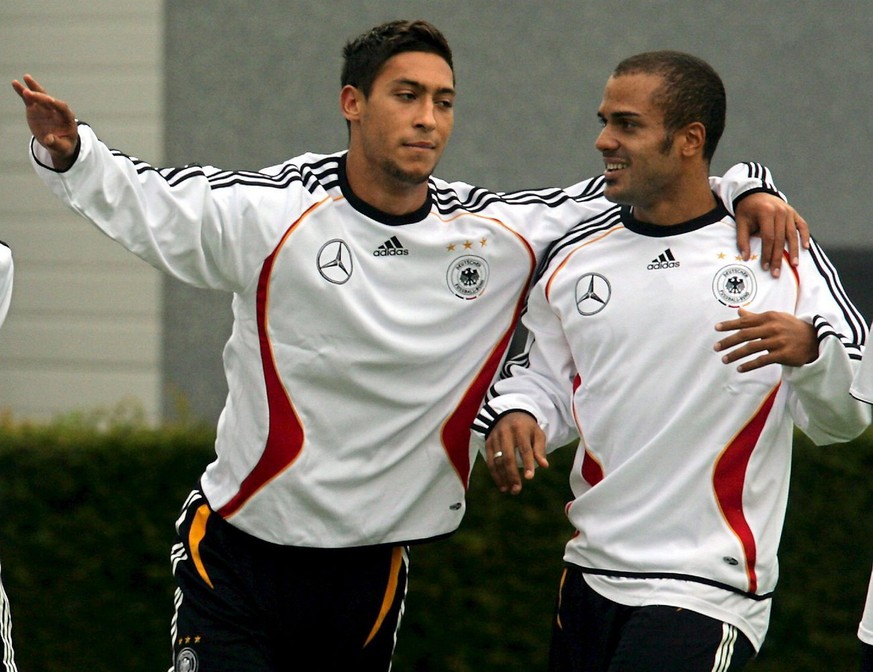 German national soccer player Malik Fathi (L) hugs David Odonkor during a training session in Kamen, Germany, Tuesday, 15 August 2006. The team prepares for their first match after the World Cup, a fr ...