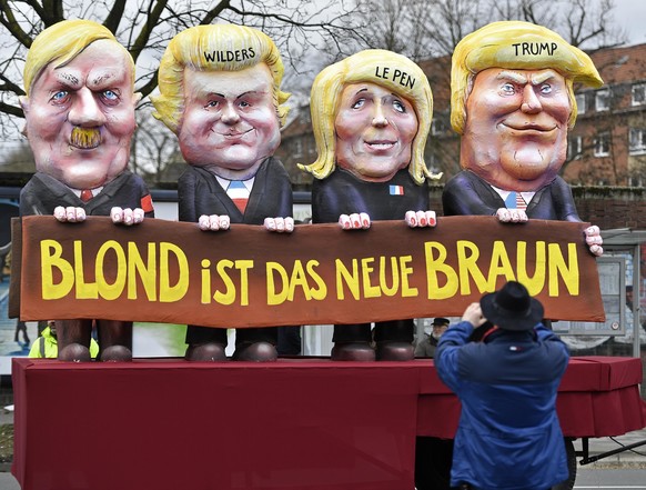 A reveller takes a picture of a carnival float depicting US president Donald Trump with Marine Le Pen, Geert Wilders and Adolf Hitler, reading &#039;blonde is the new brown&#039; prior the traditional ...