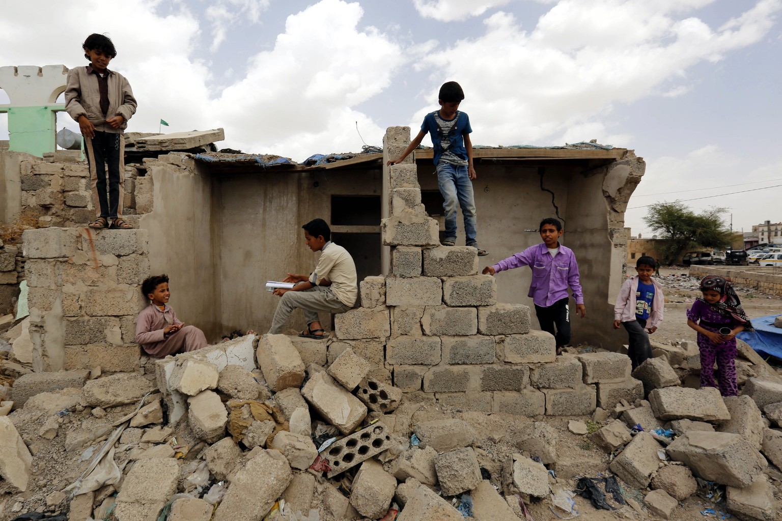epa05870207 Yemenis stand over the rubble of buildings allegedly destroyed by Saudi-led airstrikes on buildings two years ago, in Sana&#039;a, Yemen, 25 March 2017. On 26 March 2015, the Saudi-led coa ...