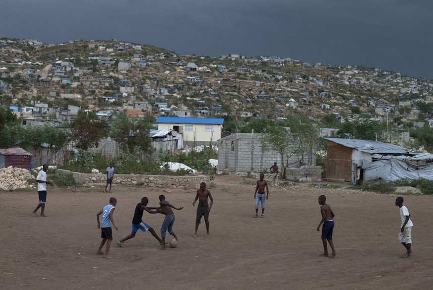 In this June 21, 2015 photo, boys play soccer in a rare open patch of land in Canaan, Haiti. In the disorganized scramble to claim free land in Canaan, settlers left room for roads, but made few plans ...