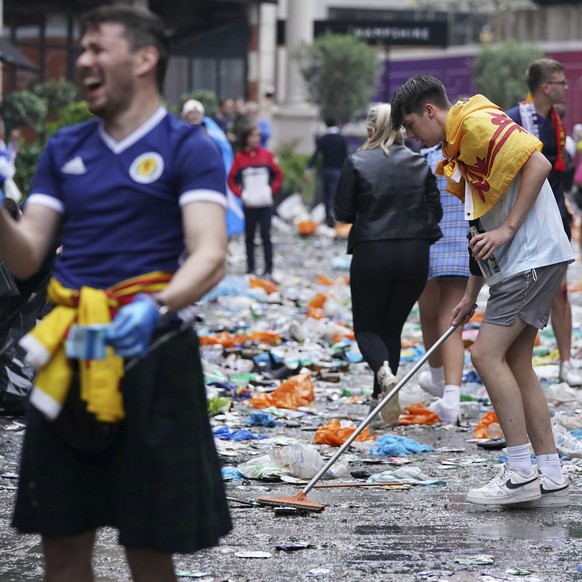 Scotland fans helps clean up litter, after fans gathered in Leicester Square prior to the Euro 2020 soccer championship group D match between England and Scotland, in London, Friday, June 18, 2021. (K ...