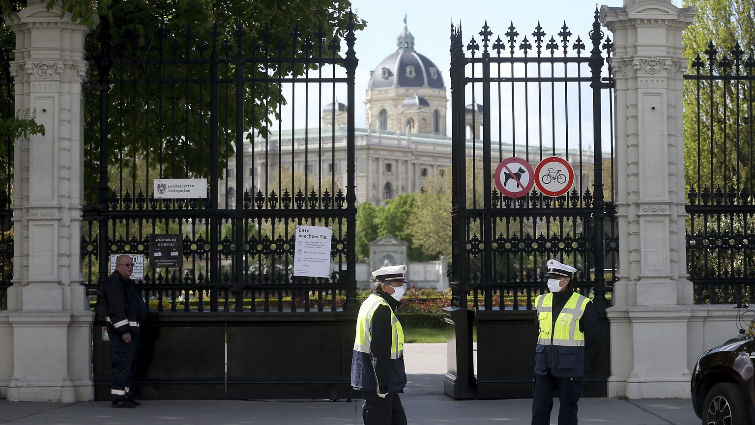 Guards with protective masks stay in front of the entrance to a park in Vienna, Austria, Tuesday, April 14, 2020. Austrian federal gardens reopen with special protective measures from Tuesday on. The  ...