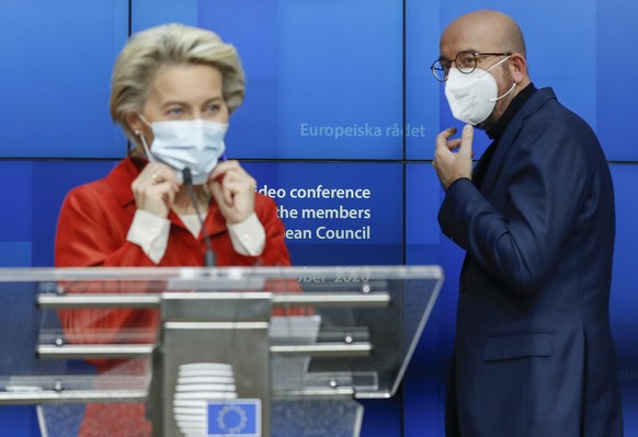 European Council President Charles Michel, right, and European Commission President Ursula von der Leyen put on their protective face mask at the end of a media conference after an EU summit in video  ...