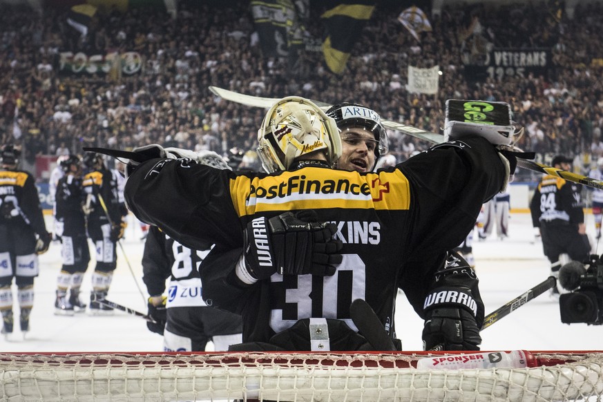 Lugano’s goalkeeper Elvis Merzlikins , left, celebrate the victory with Lugano’s player Gregory Hofmann, right, during the fifth match of the playoff final of the National League of the ice hockey Swi ...