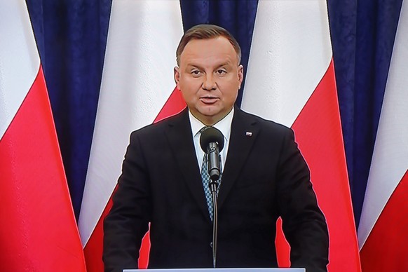 epa08315923 Broadcast of the briefing by the Polish President Andrzej Duda (on screen) after the meeting of the National Security Council (BBN) in Warsaw, Poland, 23 March 2020. The main topic of the  ...