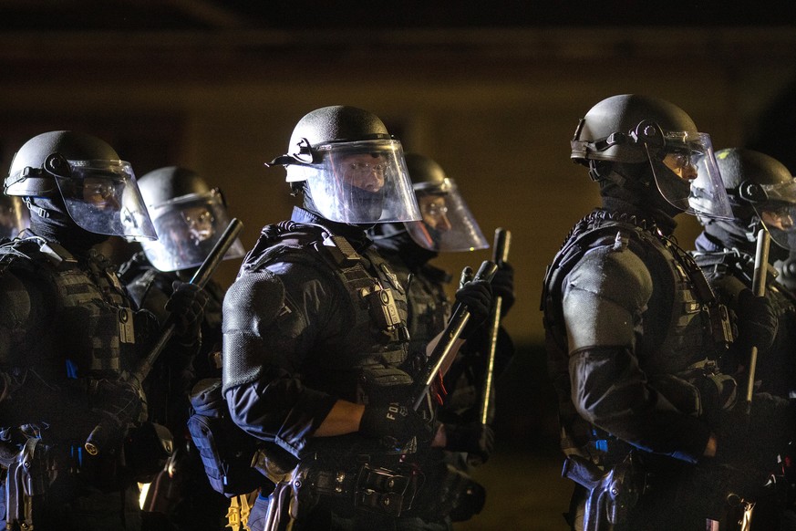 Portland police take control of the streets after making arrests on the scene of the nightly protests at a Portland police precinct on Sunday, Aug. 30, 2020 in Portland, Ore. Oregon State Police will  ...
