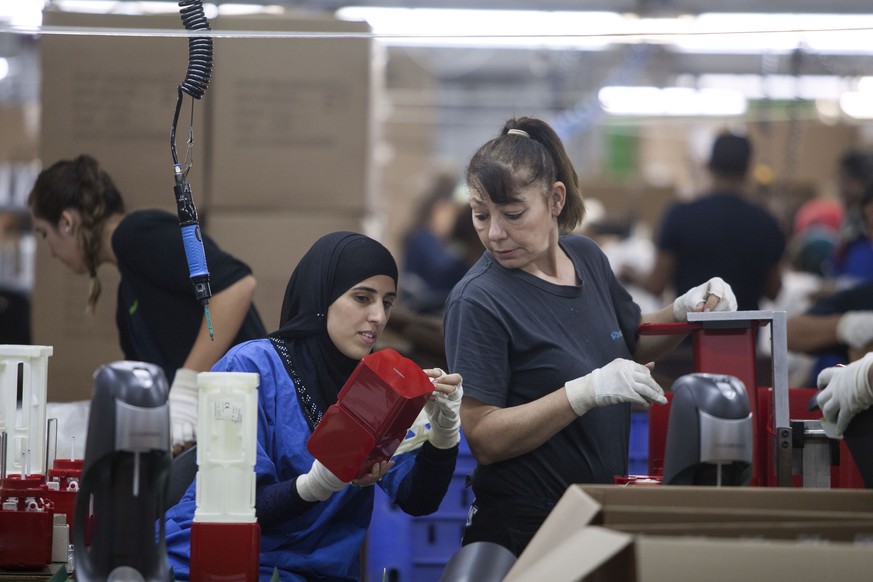 Employees work at the new SodaStream factory built deep in Israel&#039;s Negev Desert next to the city of Rahat, Israel, that will replace the West Bank facility when it shuts down in two weeks time,  ...