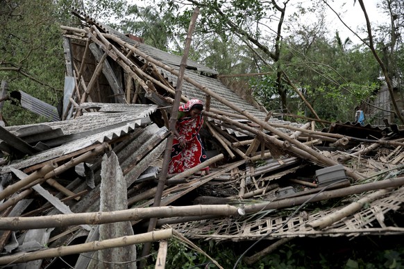 epa08435244 Family members stand among the debris of their destroyed home after after Cyclone Amphan made landfall, in Bokkhali village near the Bay of Bengal, India, 21 May 2020. The Odisha governmen ...