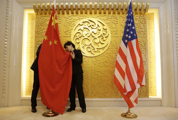 epa06695916 Staff members set up Chinese and US flags for a meeting between Chinese Transport Minister Li Xiaopeng and US Secretary of Transportation Elaine Chao at the Ministry of Transport of China  ...
