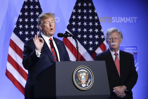 U.S. President Donald Trump, left, is flanked by national security adviser John Bolton, right during a press conference after a summit of heads of state and government at NATO headquarters in Brussels ...