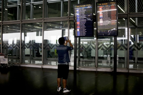 A stranded passenger takes the photograph of electronic display board showing cancelled flights at the Netaji Subhas Chandra Bose international airport after following cyclone Fani landfall in eastern ...
