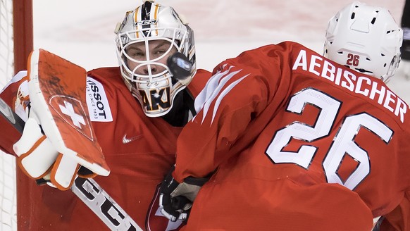 Switzerland goalie Akira Schmid and teammate David Aebischer try to stop a shot from Finland during the second period of a world junior hockey championships semifinal in Vancouver, British Columbia, F ...