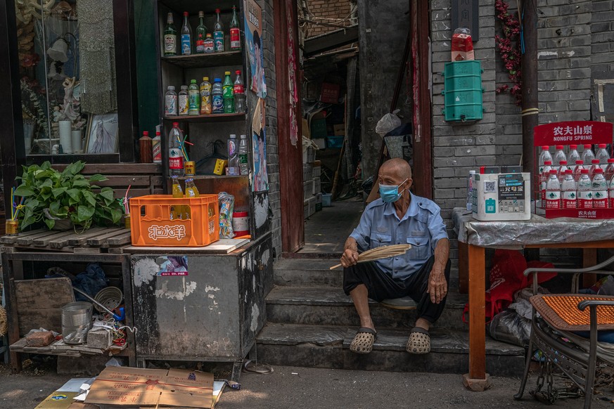 epa08507474 A man sits outside his shop in the Hutong neighborhood, amid a new coronavirus outbreak in Beijing, China, 23 June 2020 (issued 25 June 2020). Almost 2.3 million people were tested for COV ...