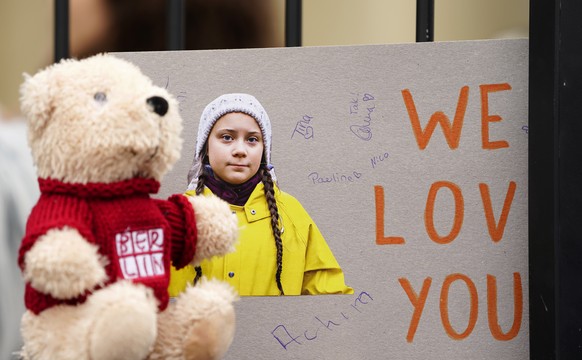 epa07470969 A cardboard with a picture of Swedish climate activist Greta Thunberg reading &#039;We love you&#039; is placed next to a teddy bear on a &#039;Fridays for Future&#039; demonstration again ...