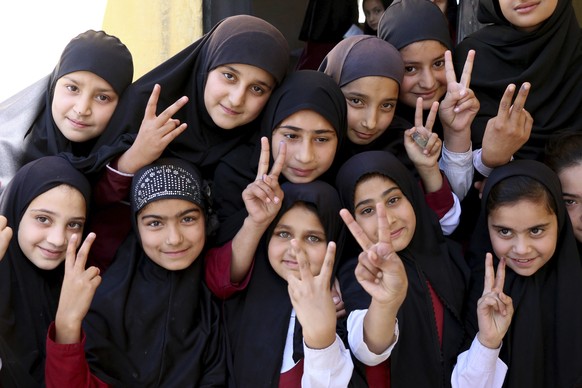 Students of the school of Nobel Peace Prize winner Malala Yousafzai flash victory sign in her hometown of Swat Valley in Pakistan, Friday, March 30, 2018. A Pakistani women&#039;s activist says Malala ...