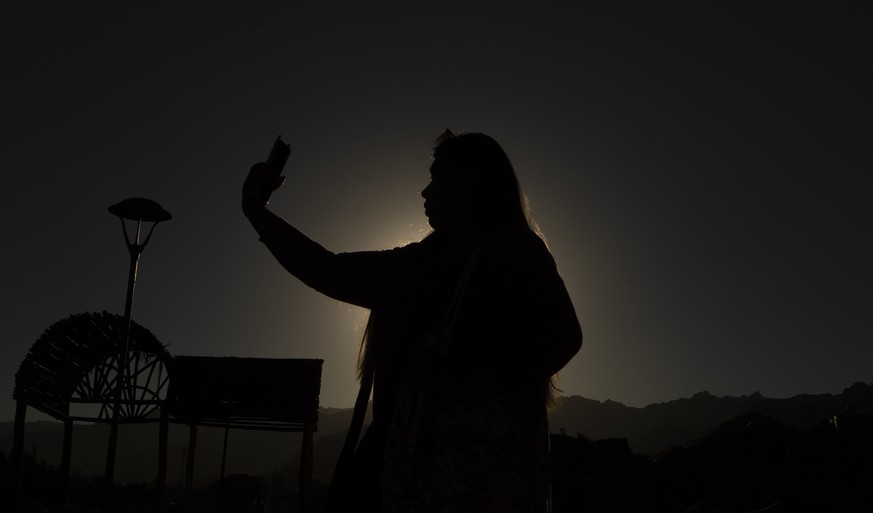 A woman takes a selfie in an astronomical complex at the University Mayor de San Andres where people gathered to watch a solar eclipse in La Paz, Bolivia, Tuesday, July 2, 2019. A solar eclipse occurs ...