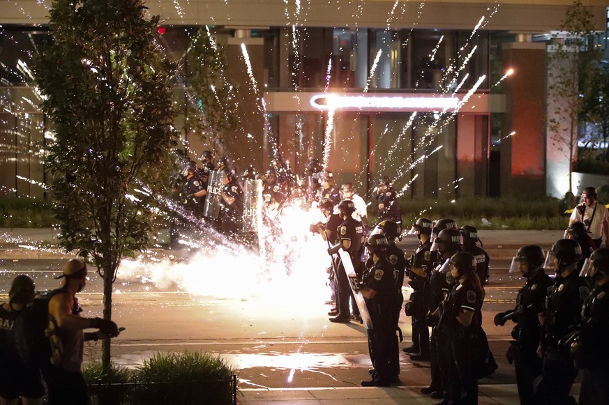 A firework explodes by a police line as demonstrators gather to protest the death of George Floyd, Saturday, May 30, 2020, near the White House in Washington. Floyd died after being restrained by Minn ...
